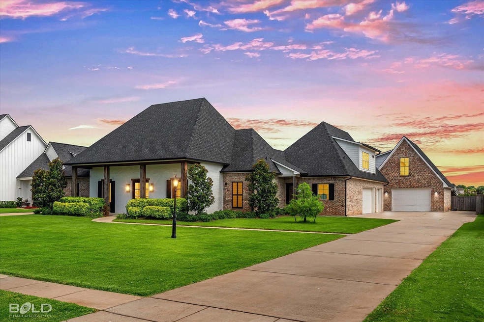 French provincial home with a garage and a lawn