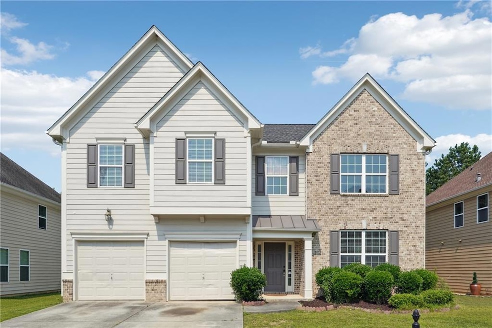View of front of property with brick siding, driveway, and a garage