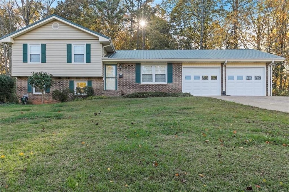 Tri-level home with a garage and a front lawn