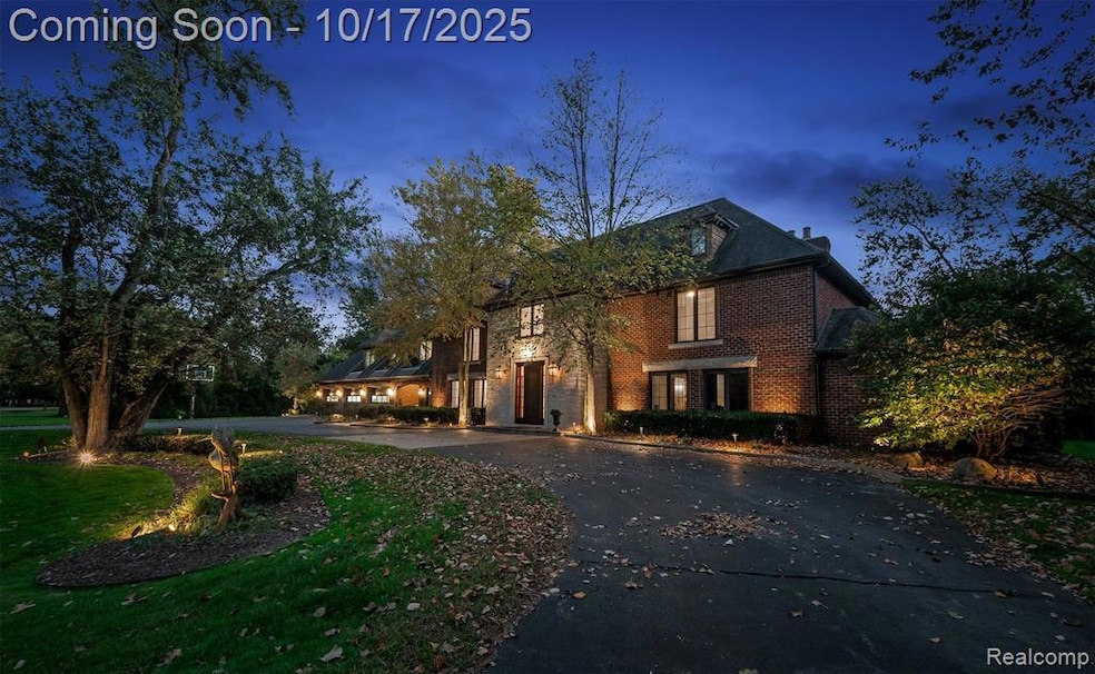 Traditional home with brick siding, curved driveway, and a front yard