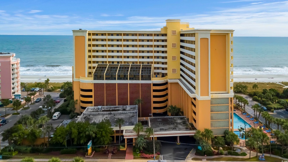 View of property featuring a water view and a beach view
