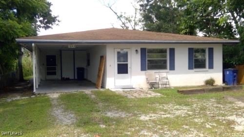 Rear view of property featuring a carport and a la