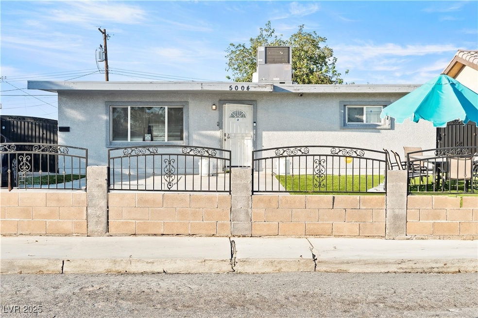 View of front of property with a fenced front yard, stucco siding, and a gate