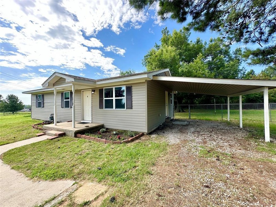 Ranch-style house with a carport and a front yard