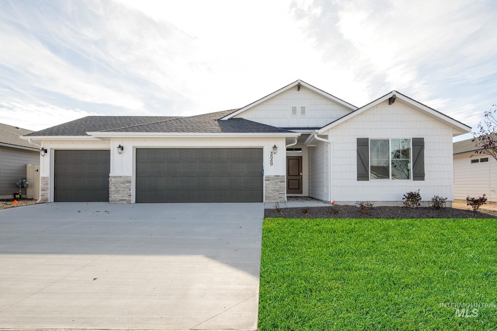 View of front of property featuring stone siding, concrete driveway, a garage, and a front yard