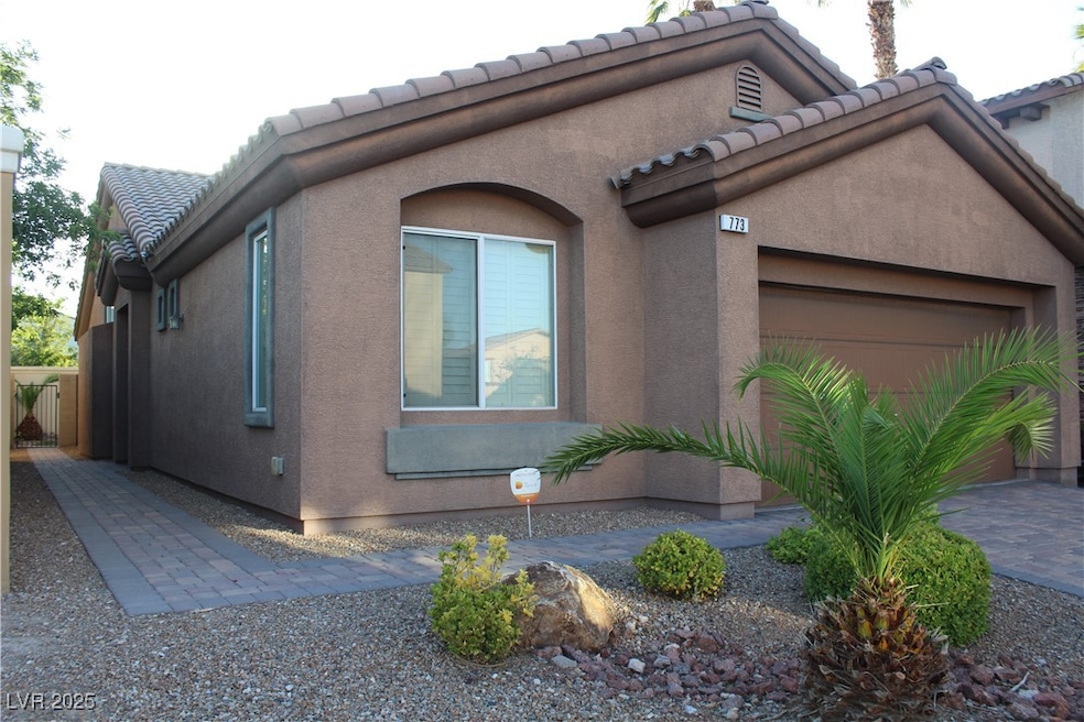 View of front of home featuring a tile roof, a gar
