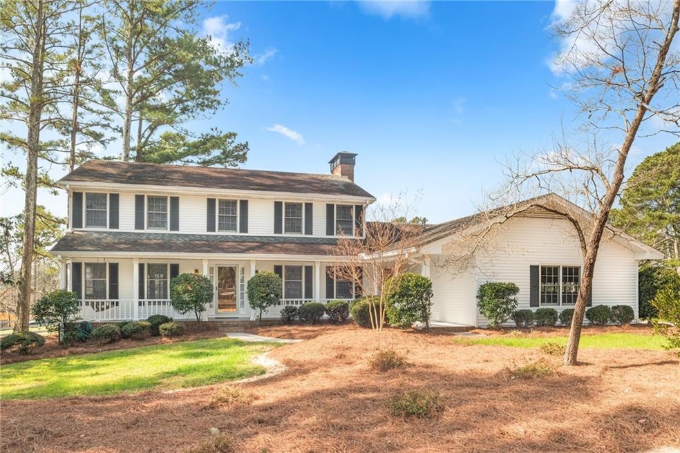 View of front facade with a porch and a chimney