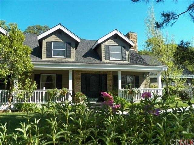 The entry to this home is surrounded by lovely gar