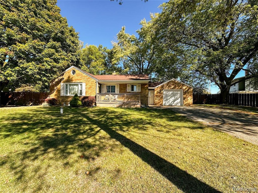 Ranch-style house featuring driveway, brick siding, a porch, and a garage