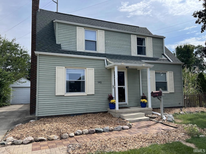 With large driveway to detached garage.