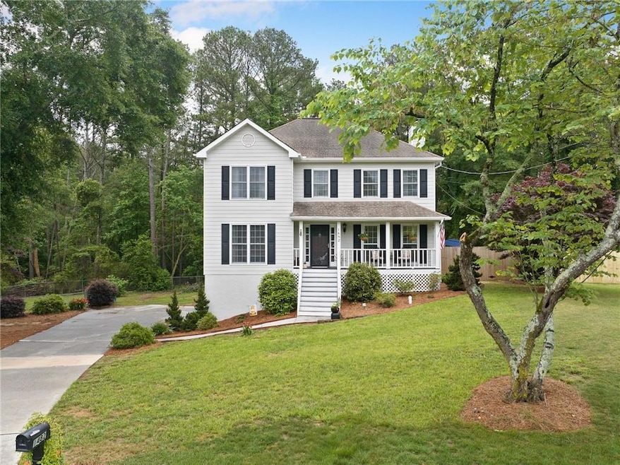 Colonial home with covered porch, a front lawn, ro