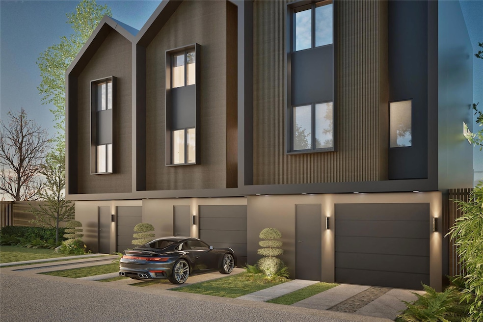 View of front of house with a garage, driveway, and stucco siding
