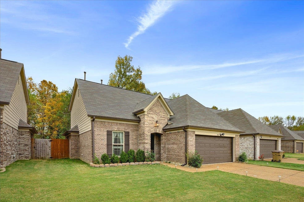 French provincial home with a front lawn and a gar