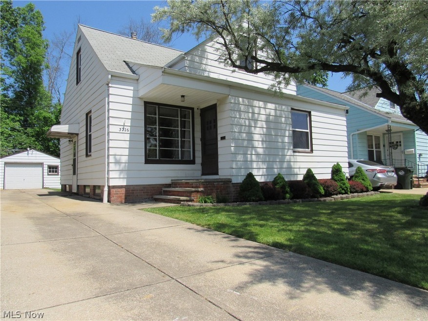 View of front of house featuring a front yard, a garage, and an outdoor structure