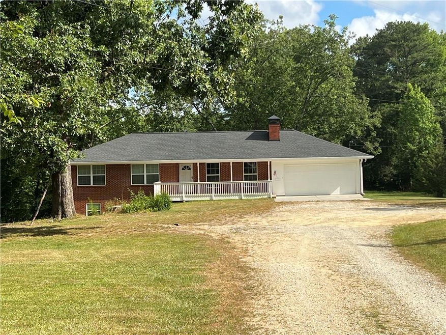 Ranch-style house featuring a garage and a front yard