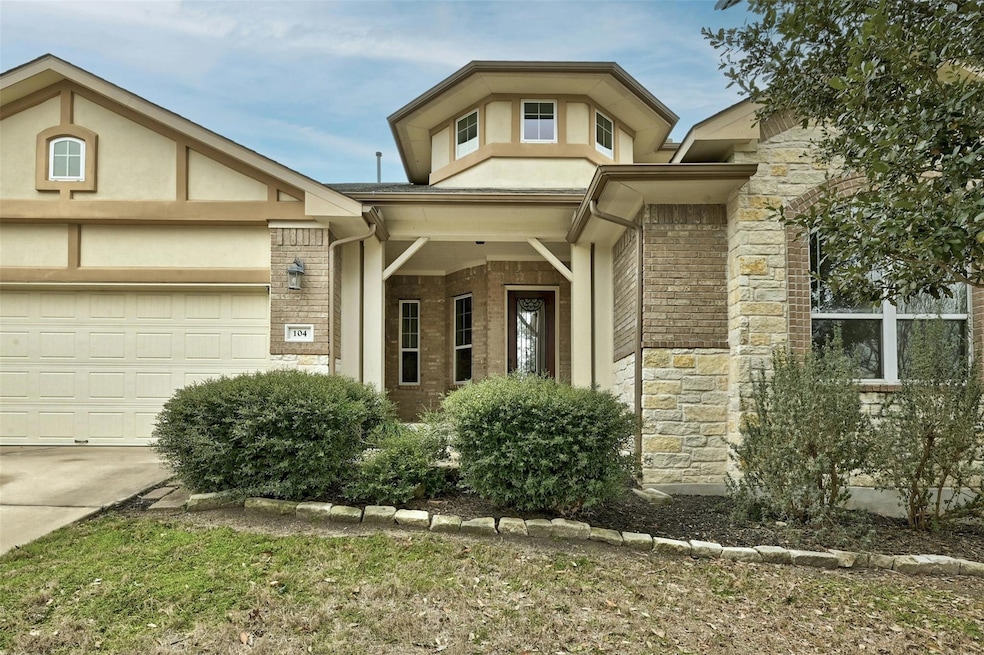 View of front facade featuring stone siding, driv
