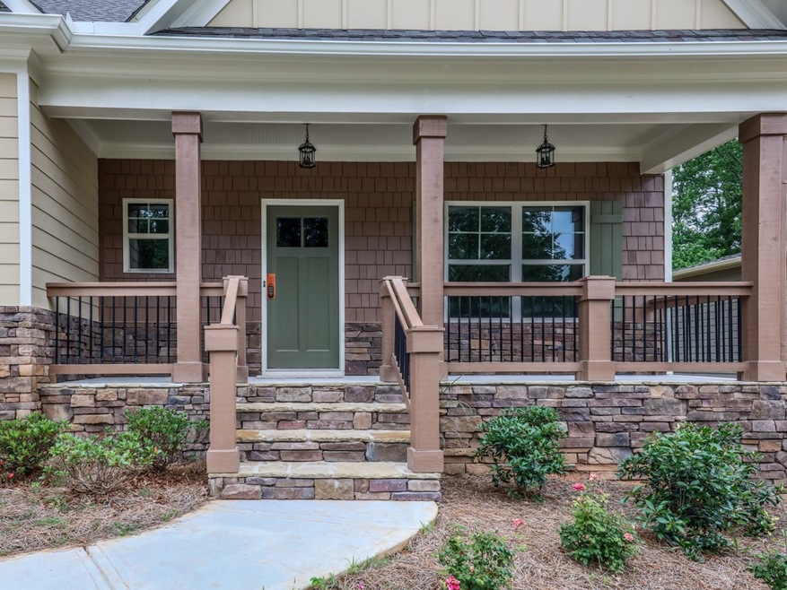 Stone steps lead to an inviting front porch featur