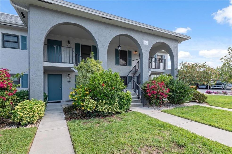 View of front facade with stucco siding, a front lawn, stairs, and a porch