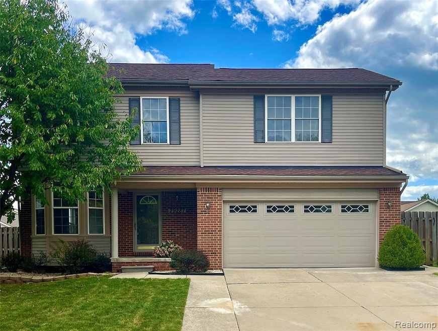 Traditional-style home featuring brick siding, concrete driveway, and an attached garage