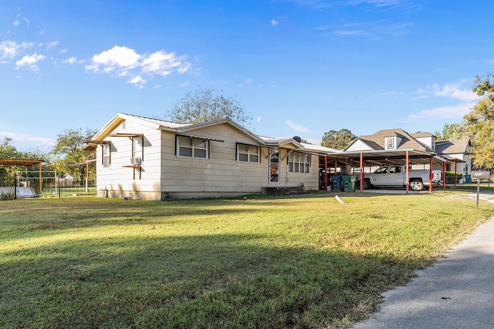 View of front of property with a front lawn and an attached carport
