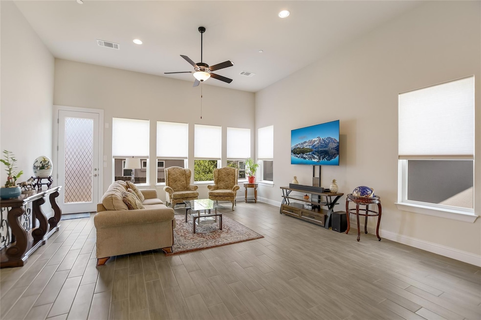 Living room with baseboards, ceiling fan, visible