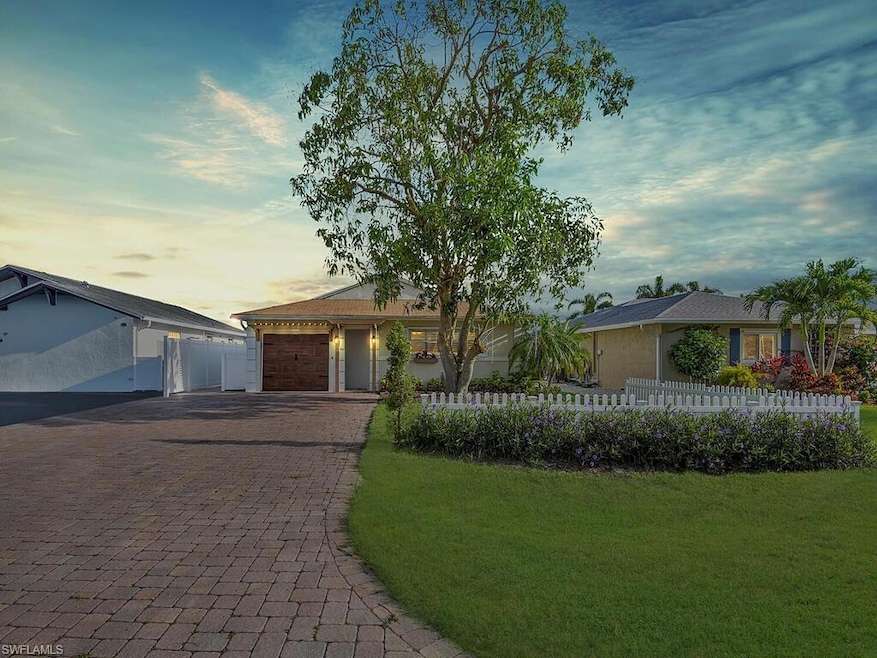 Ranch-style home with a fenced front yard, decorative driveway, and a garage
