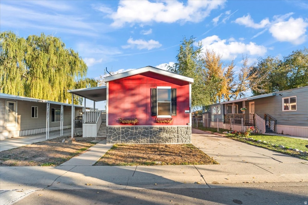 Manufactured / mobile home with stairway, driveway, and a porch