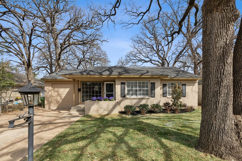 Single story home with brick siding, a garage, dri