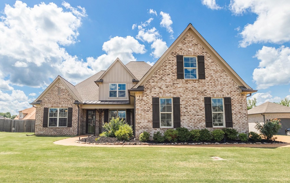 View of front of property with brick siding, a standing seam roof, and board and batten siding