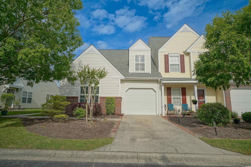 View of front of house featuring brick siding, concrete driveway, roof with shingles, covered porch, and a garage