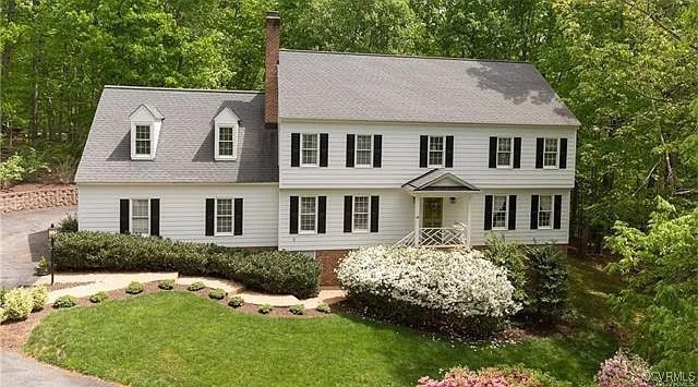 Colonial house with a front yard and a chimney