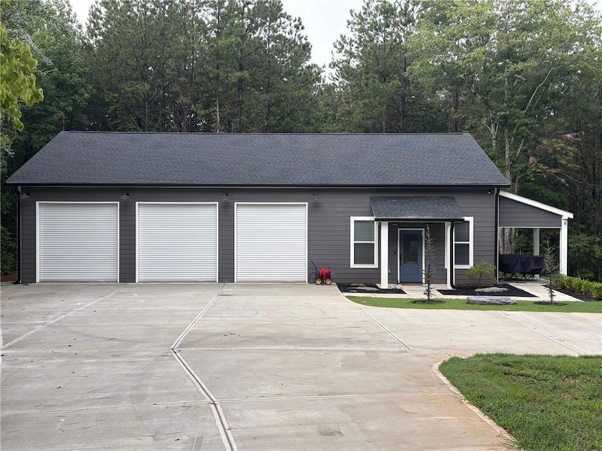 View of front of home with driveway, roof with shingles, a porch, and a garage