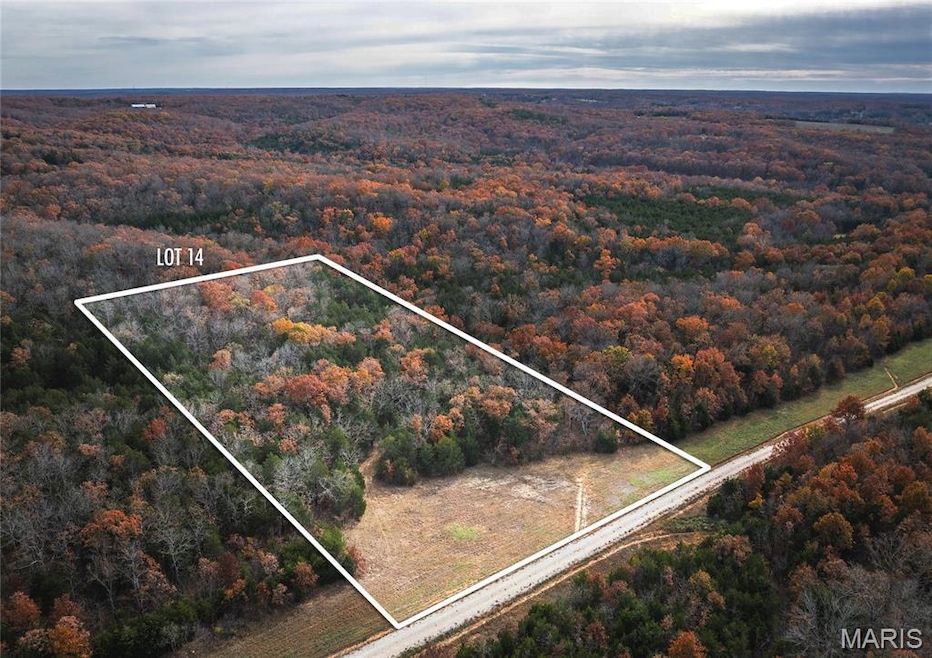 Aerial view of property's location featuring property boundaries highlighted and a forest