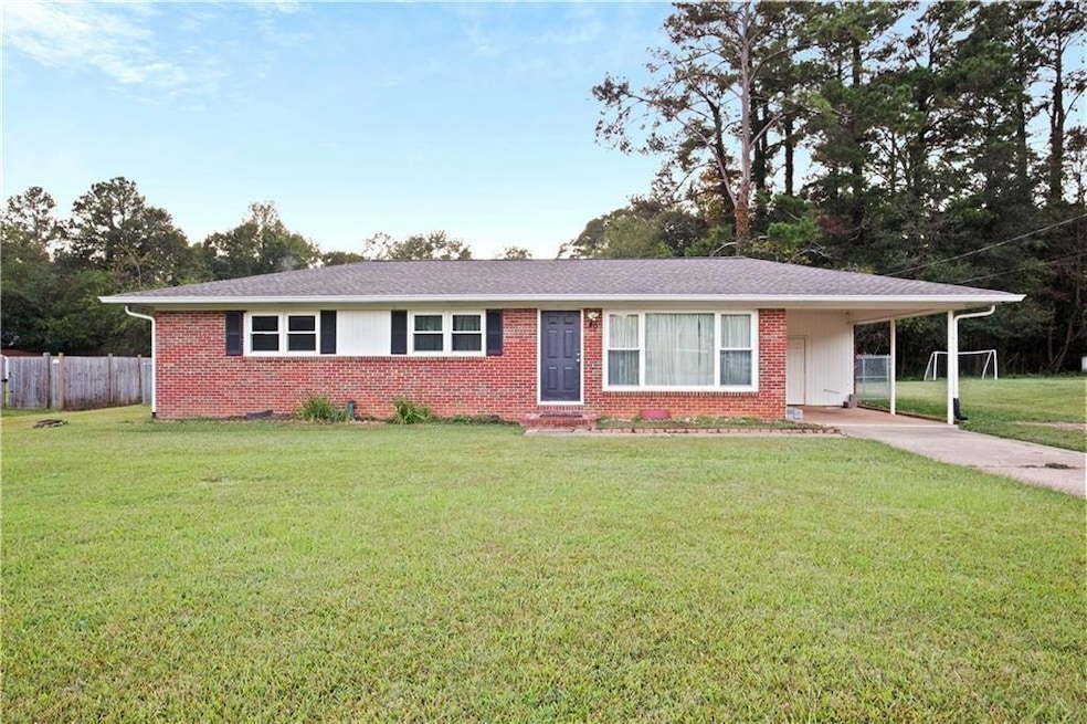 Ranch-style house featuring a front lawn and a car