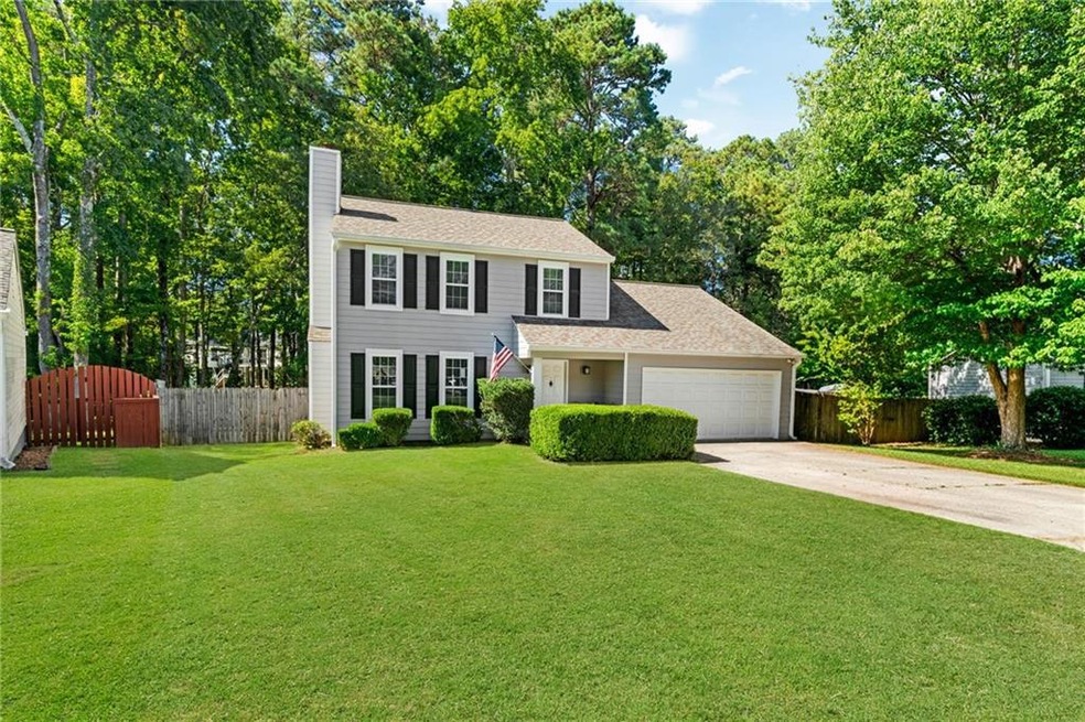 Colonial style home with driveway and level lot trucked away in the cul-de-sac.