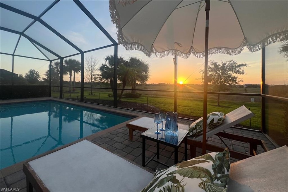 Pool at dusk with a yard, glass enclosure, a patio