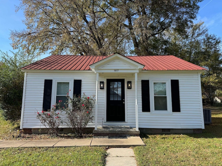 Bungalow-style house with crawl space, metal roof, central air condition unit, and a front lawn