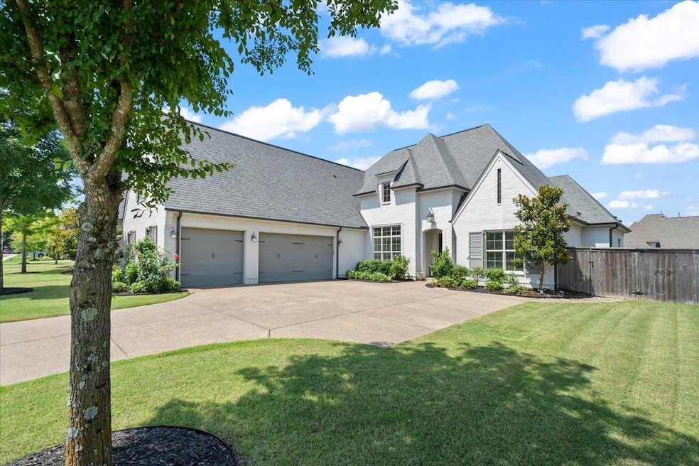 French country home featuring a garage, concrete driveway, and a shingled roof