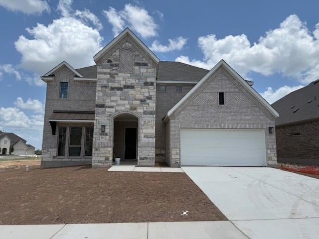 French country home with driveway, stone siding, 
