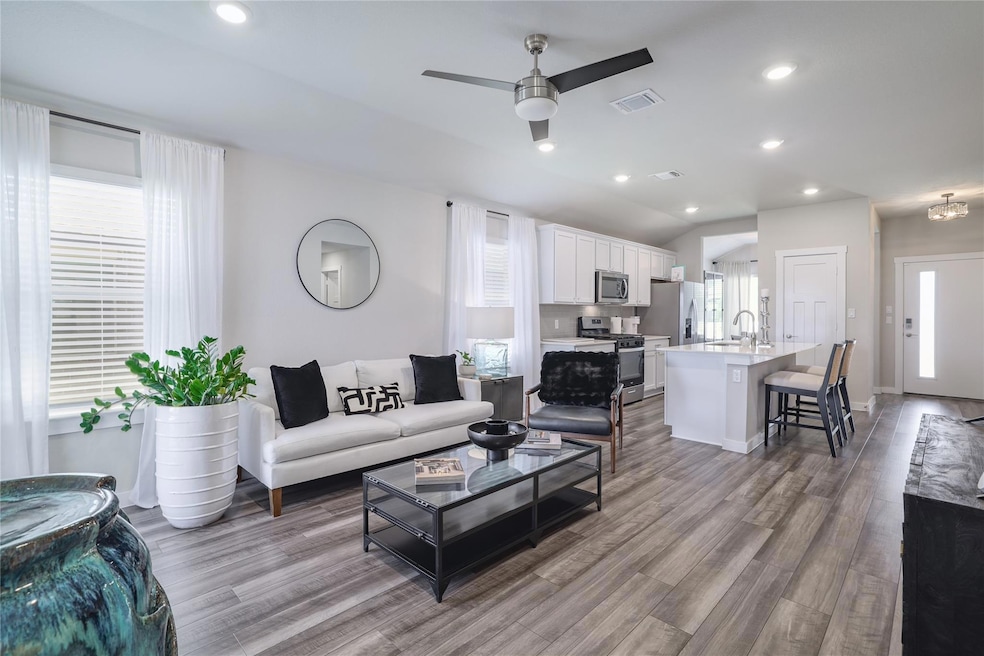 Living area with a ceiling fan, wood finished flo