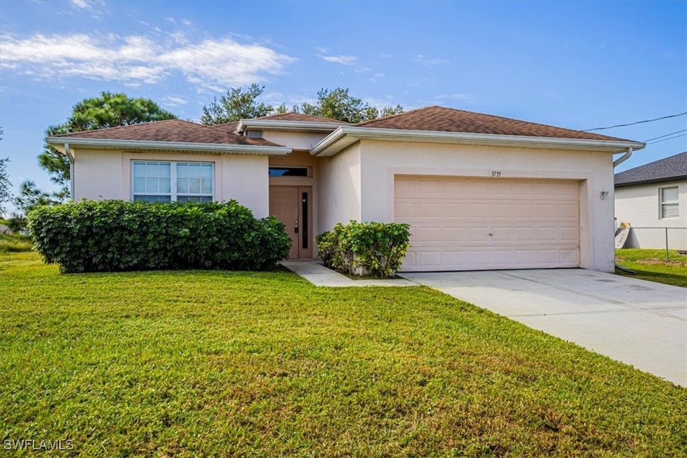 View of front of home featuring stucco siding, concrete driveway, a front lawn, and an attached garage