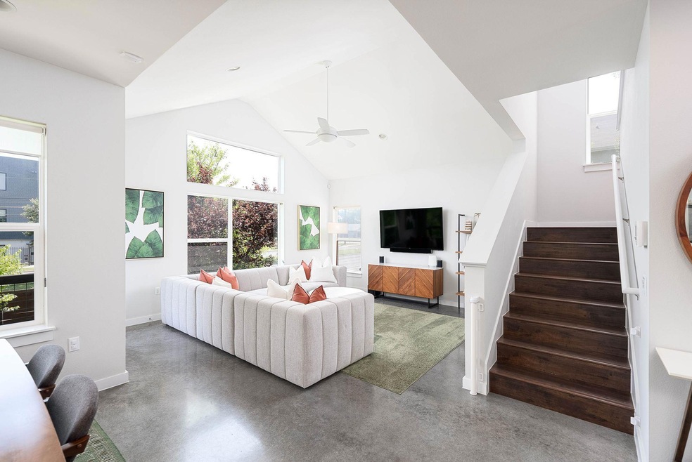 Living room with concrete flooring, a ceiling fan