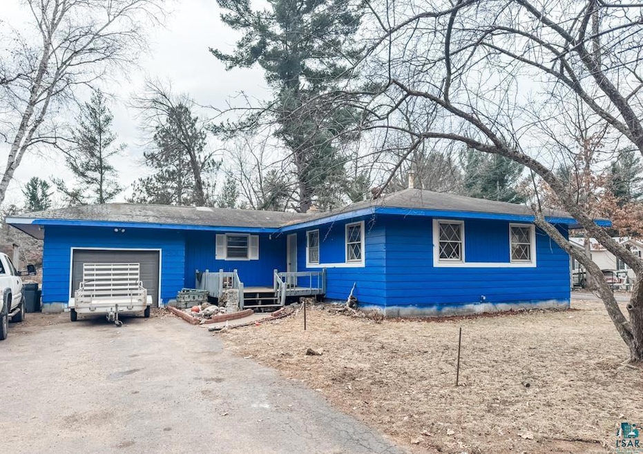 Single story home featuring aphalt driveway and an