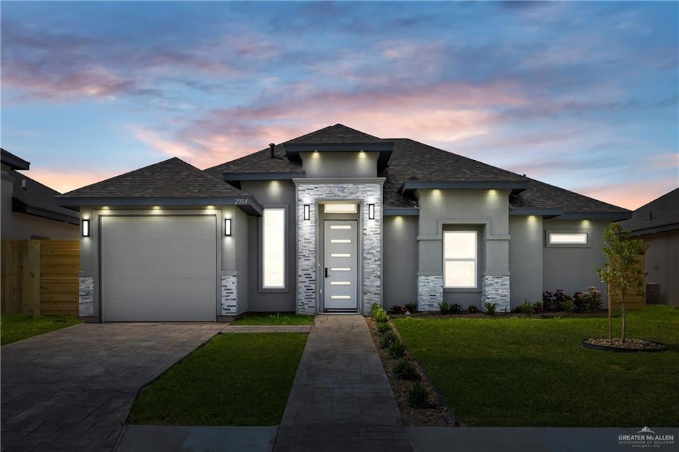 Prairie-style home featuring an attached garage, fence, stucco siding, a front lawn, and driveway