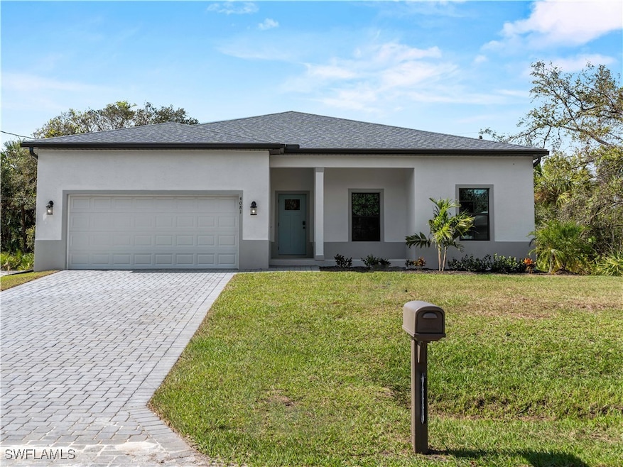 View of front facade with a garage and a front law