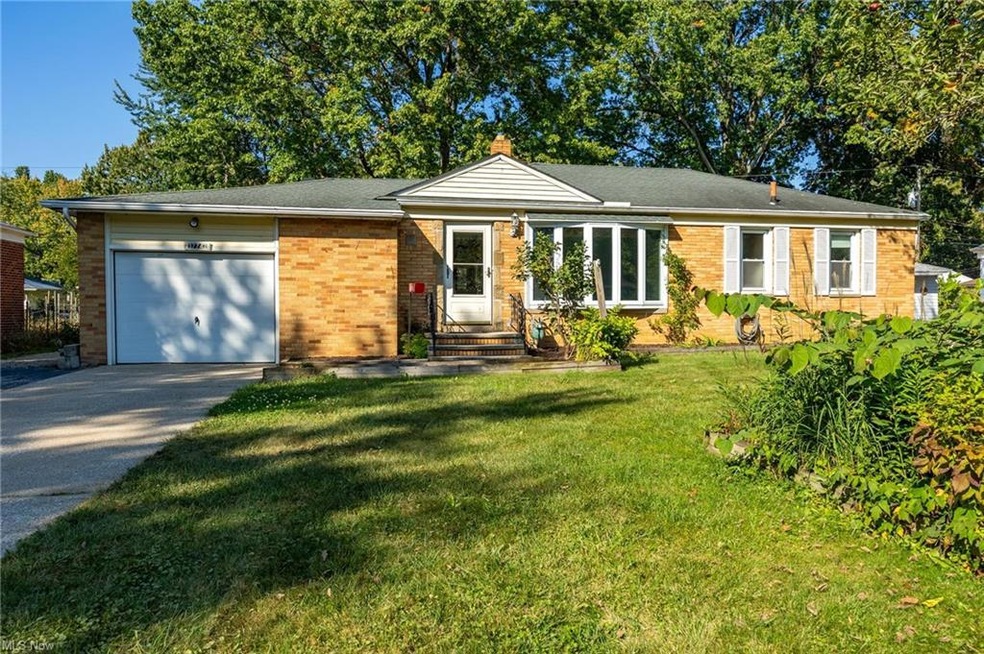 Ranch-style house featuring a front lawn and a gar