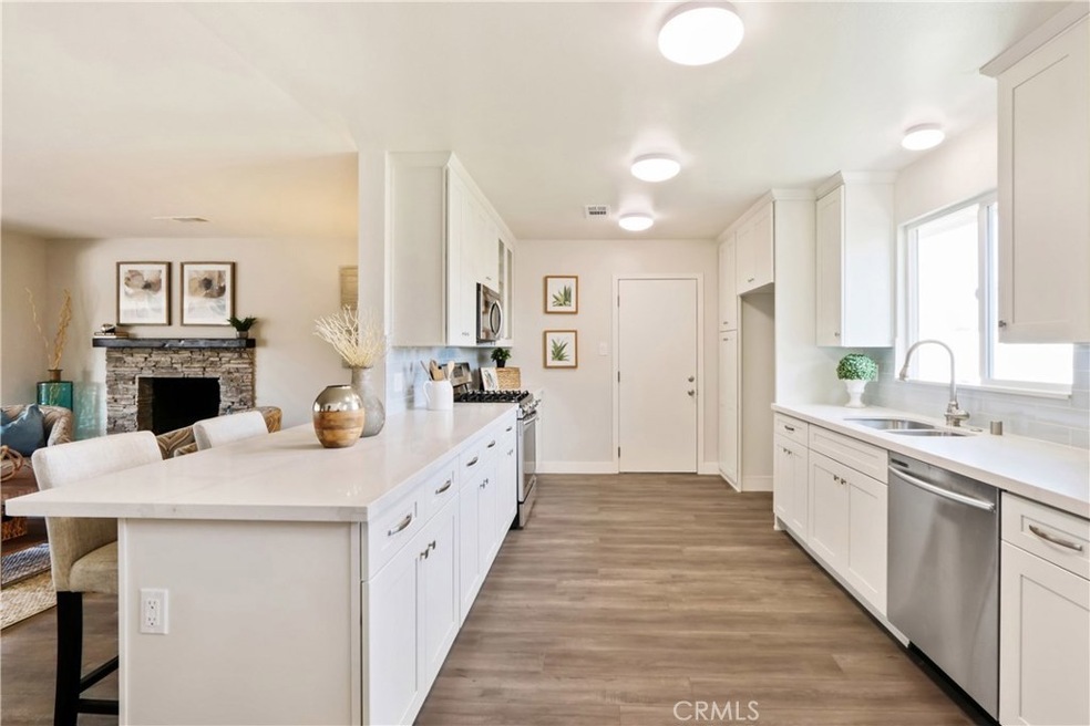 Remodeled kitchen with brand new shaker style cabinets, quartz counters, subway tile backsplash, waterproof vinyl plank flooring and stainless steel appliances.