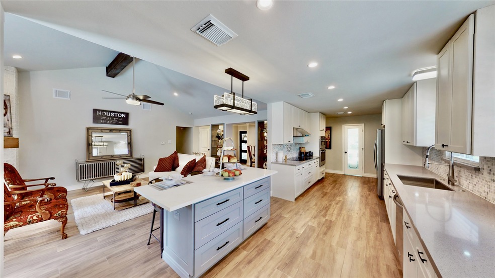 Large living room has a vaulted ceiling and is ope