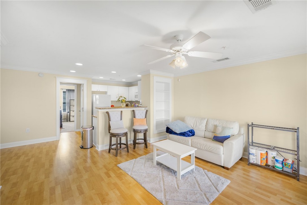 Living area with crown molding, light wood finishe