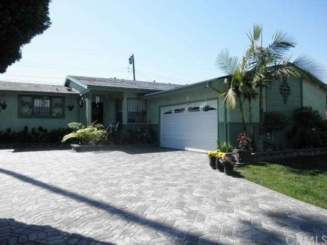 Lovely landscaping and driveway pavers give this h